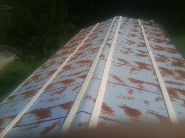 Rusted metal roof panels with new wood purlins before replacement — Storm Damage Roof Repair in Firestone by Roofing Brothers