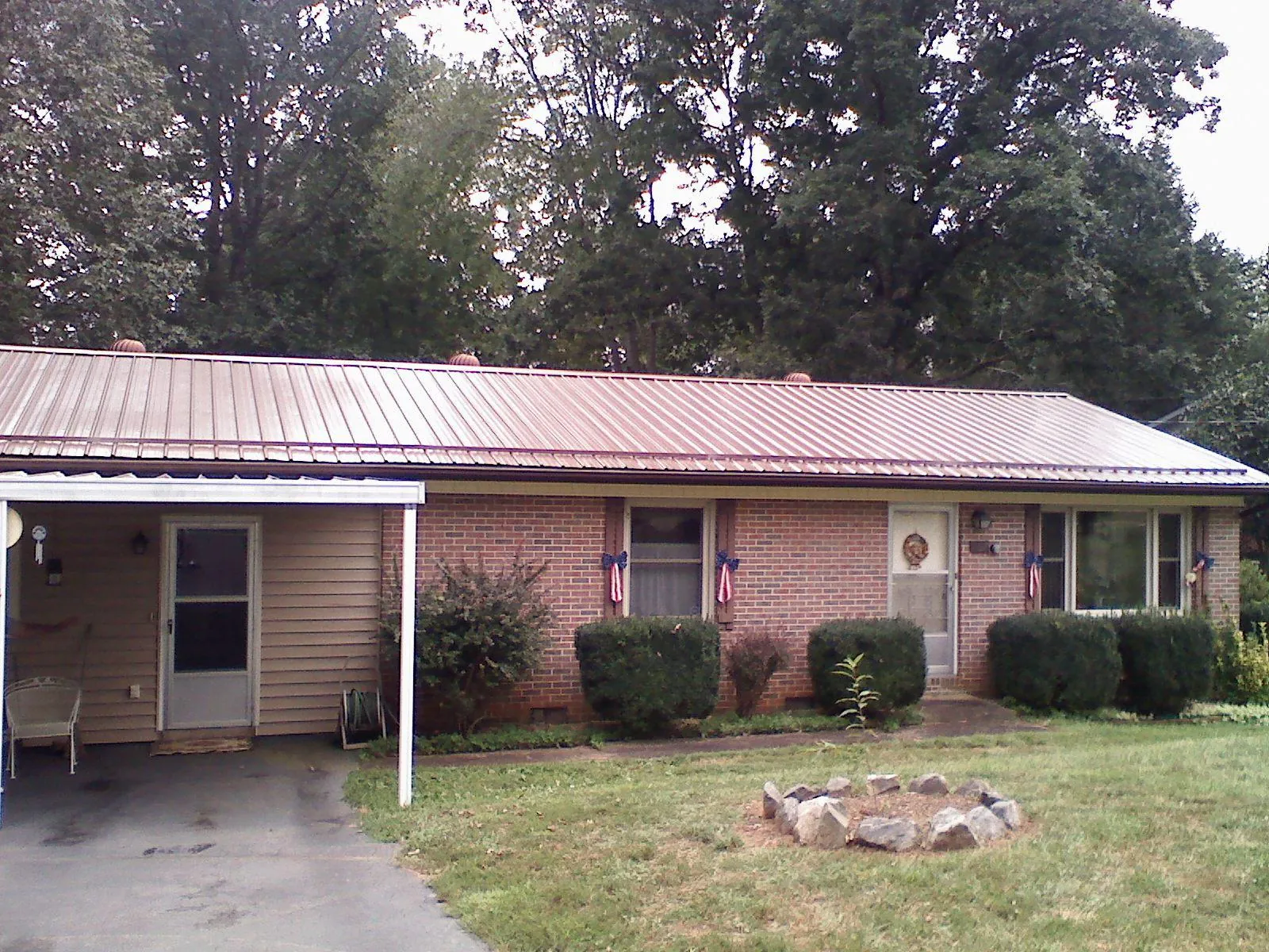 Bronze metal roof and carport on a brick ranch home — Roof Repair work by our crew in Firestone